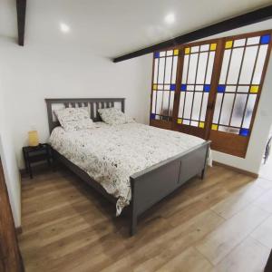 Saint-PrivatGîte de l'atelier的一间卧室配有一张铺有木地板的床和窗户。