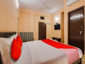 Pedda AmbarpetOYO R.J.international的配有红色枕头的床的酒店客房