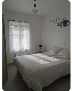 蒙特尔梅La petite maison的卧室配有一张床铺,墙上有一眼