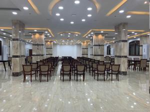Al KhārijahBadr Hotel & Resort El Kharga的大楼内带桌椅的宴会厅