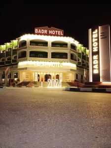Al KhārijahBadr Hotel & Resort El Kharga的一座大型建筑,晚上有酒吧酒店