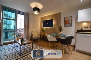 利兹LGI Stunning 1 Bedroom Apartment By Movida Property Group Short Lets & Serviced Accommodation的一间带桌子的客厅和一间餐厅