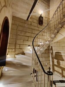 卢加Peaceful Traditional Maltese Townhouse的一座石头墙建筑中的螺旋楼梯