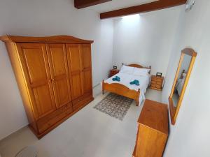 卢加Peaceful Traditional Maltese Townhouse的一间卧室配有一张床和一个木制橱柜
