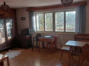 HutiskoChata na Poskle u lesa s výhledem的一间设有两张桌子和窗户的用餐室