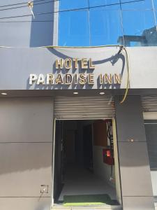 ShinayaHOTEL PARADISE INN的大楼前的酒店天堂旅馆标志