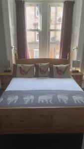 奥本Ardvaich House的一间卧室配有一张带蓝色床单和窗户的床。