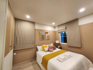 Ban Thap NangNARAH的卧室配有一张带黄色枕头的大型白色床。
