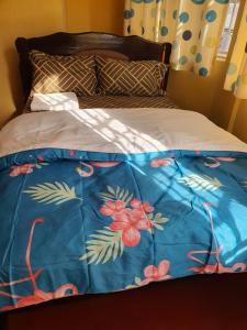 KagioMAGGY LODGE的一张床上,床上有鲜花,有蓝色的毯子