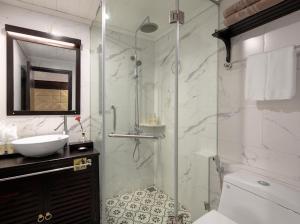 下龙湾Hạ Long Aqua Legend Cruise的一间带玻璃淋浴和水槽的浴室