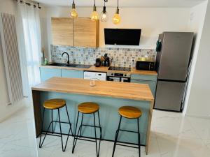 蒙彼利埃Appartement Premium 4 Stars - Antigone的厨房配有带2把凳子的柜台和冰箱。
