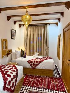 舍夫沙万Dar MD的一间卧室配有两张床和吊灯。