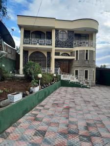 亚的斯亚贝巴Addis Joy Guesthouse的前面有砖瓦车道的大房子