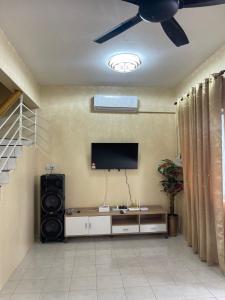 拿笃B&K Homestay Lahad Datu的客厅配有吊扇和平面电视。