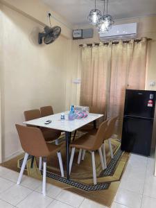 拿笃B&K Homestay Lahad Datu的一间配备有白色桌椅的用餐室
