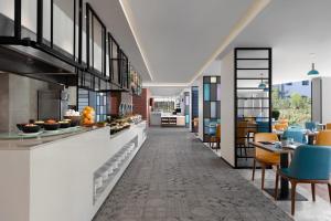 长滩岛Four Points by Sheraton Boracay的餐厅设有长长的走廊,配有桌椅