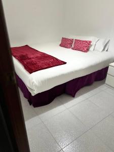 卡塔罗哈Habitación por días的一张床上的红色枕头