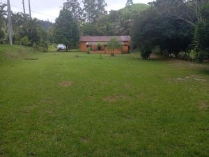 瓜拉派瑞Camping Casa Velha的一个带房子和绿地的庭院
