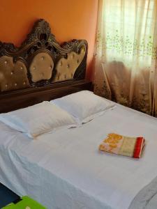 达卡Hotel Short Time Stay的一张带华丽床头板和枕头的白色床