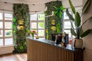 普尔海姆Kontaktlos Hotel Vintage的大堂设有绿墙,种植了植物