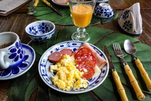 伊波兰加Glamping Mangarito的一张桌子,上面放着一盘早餐食品和一杯橙汁