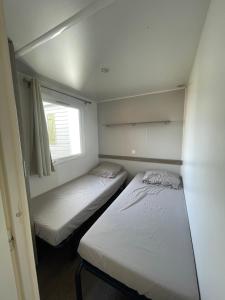 拉努韦勒港Mobil Home de Marine的小型客房 - 带2张床和窗户