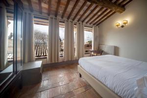 福利尼奥La Maestà antica dimora di campagna的一间卧室设有一张床和一个大窗户