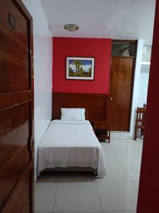 齐克拉约Hotel ESPLENDOR的卧室配有白色的床铺和红色的墙壁
