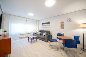 巴利亚多利德Apartamentos GO - Génova Parquesol - Parking Gratuito的客厅配有沙发和桌子