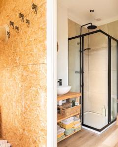 RanstGehele accommodatie met boshuisje en 3 woonwagens的一间带玻璃淋浴和水槽的浴室