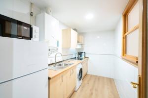 巴利亚多利德Apartamentos GO - Génova Parquesol - Parking Gratuito的厨房配有水槽和洗衣机