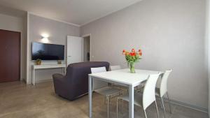 波代诺内Al Civico 2的客厅配有桌椅和电视。