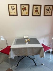 巴里Casa Garruba Central Station的一张餐桌,配有两把红色椅子和白色的墙壁