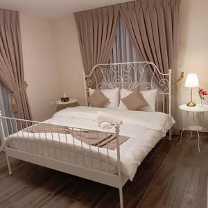 安曼安曼精品酒店的一间带白色床和金属床头的卧室