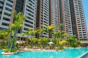 圣保罗Incrível resort paradisíaco!的一座棕榈树环绕的游泳池,位于高楼前