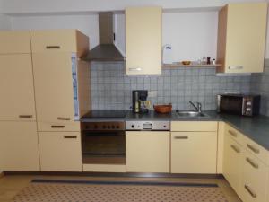 施特罗布尔K3 Ferienhaus的厨房配有白色橱柜和水槽