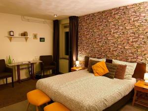 博克斯特尔Gasterij Hotel Dennenoord的一间卧室设有一张床和砖墙
