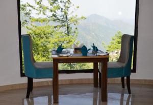 西姆拉Nature Mountain Valley View Resort -- A Four Star Luxury Resort的桌椅,享有山景