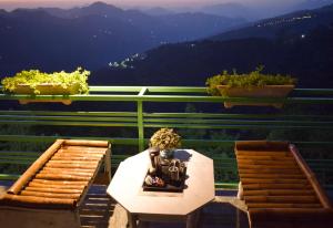 西姆拉Nature Mountain Valley View Resort -- A Four Star Luxury Resort的美景阳台配有一张桌子和两把椅子