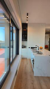 塔尔图Artisa Riia Str 22 Luxury Penthouse Apartment - 8th fl的一间带白色柜台和大窗户的厨房