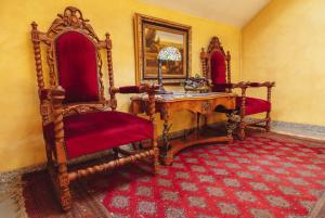 采列格兰德酒店的一间设有两把椅子和一张木桌的房间