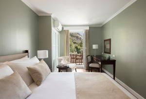 直布罗陀洛克酒店的一间卧室配有一张床、一张桌子和一把椅子
