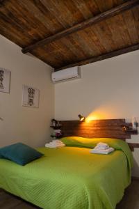 科米索Filuvespri的一间卧室配有一张绿色的床和木制床头板