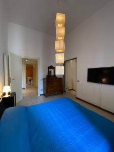 利沃诺Appartamento Al Teatro的一间卧室配有蓝色的床和一台平面电视