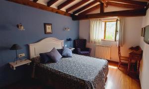 图里恩奥Picos de Europa Suites and Rooms的卧室配有床、椅子和窗户。