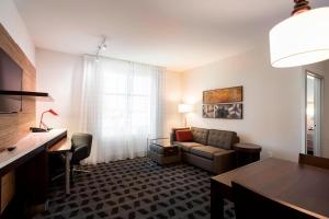 福斯特城圣马特奥福斯特城万豪广场套房酒店的客厅配有沙发和桌子