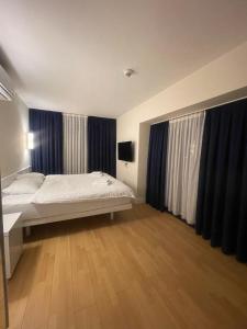 巴统Orbi city Panorama towers的一间卧室配有床和蓝色窗帘