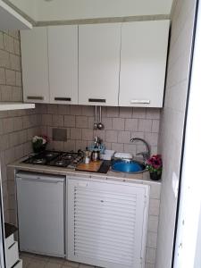 普罗奇达casetta mariapia的厨房配有白色橱柜和水槽