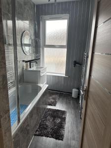 大雅茅斯Impeccable 3-Bed House in Great Yarmouth的带浴缸、水槽和窗户的浴室
