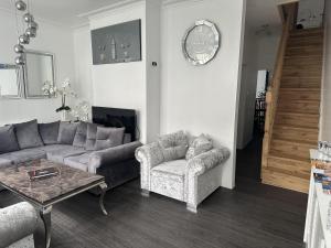 大雅茅斯Impeccable 3-Bed House in Great Yarmouth的带沙发、桌子和时钟的客厅